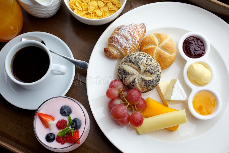 Rijke continentale ontbijt Franse knapperige croissants, muesli, veel zoete vruchten en bessen, hete koffie voor ochtend stock afbeelding Rijke continentale ontbijt Franse knapperige croissants, muesli, veel zoete vruchten en bessen, hete koffie voor ochtend stock afbeelding
