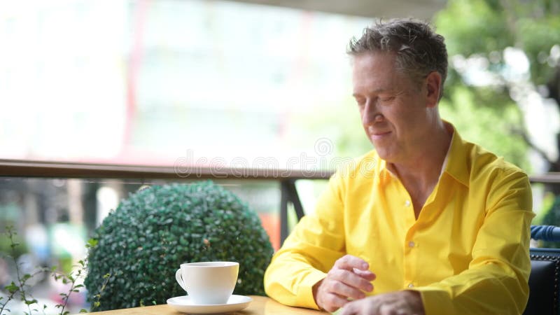 Rijp Knappe Mensenzitting in Koffiewinkel terwijl het Gebruiken van Mobiele Telefoon