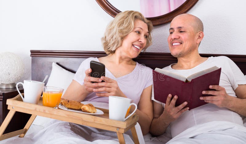Rijp paar dat ontbijt in bed heeft royalty-vrije stock afbeeldingen Rijp paar dat ontbijt in bed heeft royalty-vrije stock afbeeldingen