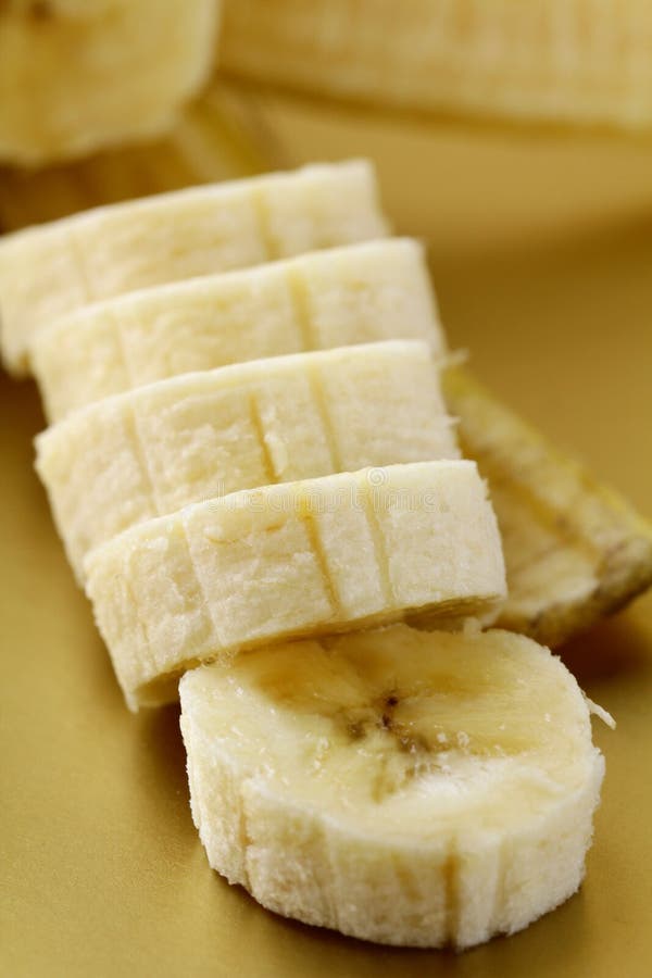 Ripe banana cut into slices on a gold background. Ripe banana cut into slices on a gold background