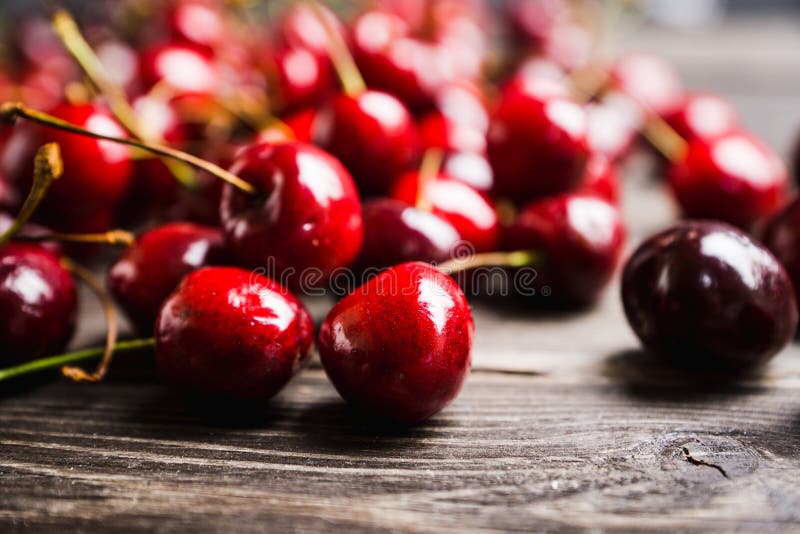 Ripe and juicy cherries on the dark rustic background. Selective focus. Shallow depth of field. Ripe and juicy cherries on the dark rustic background. Selective focus. Shallow depth of field.