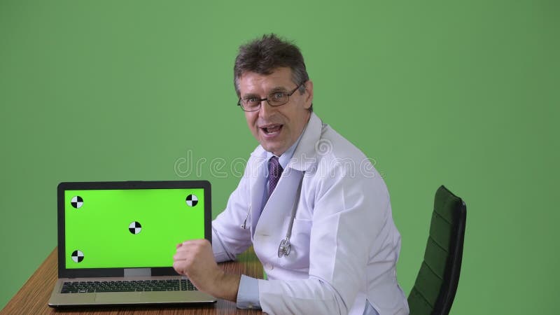 Rijpe knappe mens arts tegen groene achtergrond