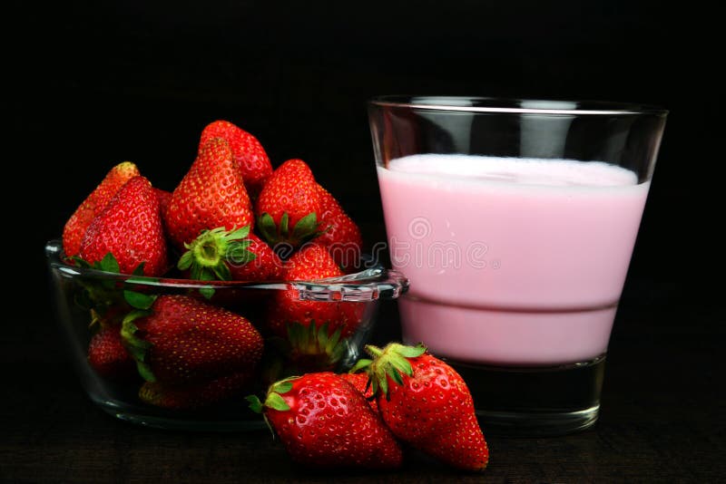 Rijpe Sappige en Verse Aardbei in een kom met een glas van milkshake op houten achtergrond royalty-vrije stock afbeeldingen Rijpe Sappige en Verse Aardbei in een kom met een glas van milkshake op houten achtergrond royalty-vrije stock afbeeldingen
