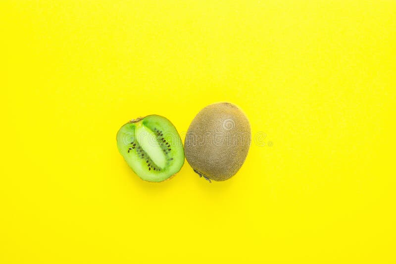 Rijpe Sappige Gehele en Gehalveerde Kiwi op Stevige Gele Achtergrond Van de Zomerdetox van de vitaminengezonde voeding de Veganis royalty-vrije stock fotografie Rijpe Sappige Gehele en Gehalveerde Kiwi op Stevige Gele Achtergrond Van de Zomerdetox van de vitaminengezonde voeding de Veganis royalty-vrije stock fotografie