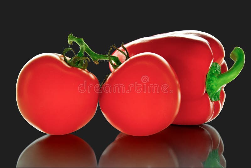 Rijpe tomaten en peper, op een zwarte achtergrond. stock afbeeldingen Rijpe tomaten en peper, op een zwarte achtergrond. stock afbeeldingen