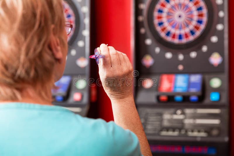 Rijpe vrouw die tegen dartboard streven royalty-vrije stock foto Rijpe vrouw die tegen dartboard streven royalty-vrije stock foto
