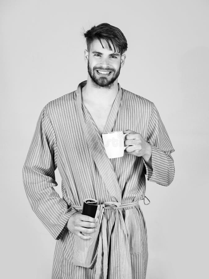 Rilassamento e svago Bere e leggere Uomo barbuto felice che sorride in abito con la tazza e la rivista immagini stock libere da diritti Rilassamento e svago Bere e leggere Uomo barbuto felice che sorride in abito con la tazza e la rivista immagini stock libere da diritti