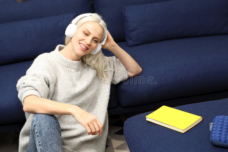 Rilassamento Una donna che si rilassa mentre ascoltando la musica sulle cuffie fotografia stock Rilassamento Una donna che si rilassa mentre ascoltando la musica sulle cuffie fotografia stock