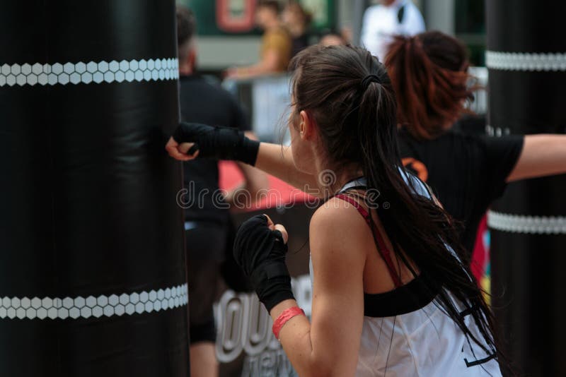 Rimini, Italy - may 2016:Young Girl with Shorts and White Tank Top: Fitness Boxing Workout with Punching Bag stock image Rimini, Italy - may 2016:Young Girl with Shorts and White Tank Top: Fitness Boxing Workout with Punching Bag stock image