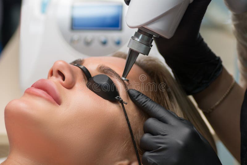 Laser removal of permanent makeup. The beautician removes the tattoo from the eyebrows. Laser removal of permanent makeup. The beautician removes the tattoo from the eyebrows.