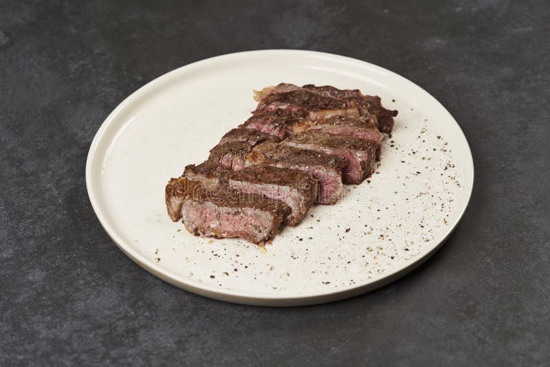 Rindfleischsteak mit Gewürzen auf einem weißen Tablett gegrillt, dicht aufgeschlossen lizenzfreie stockfotografie Rindfleischsteak mit Gewürzen auf einem weißen Tablett gegrillt, dicht aufgeschlossen lizenzfreie stockfotografie