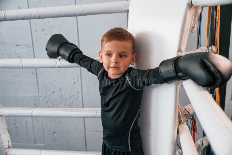 On the Ring. Boy is Practicing Boxing in the Gym with Glowes on Hands