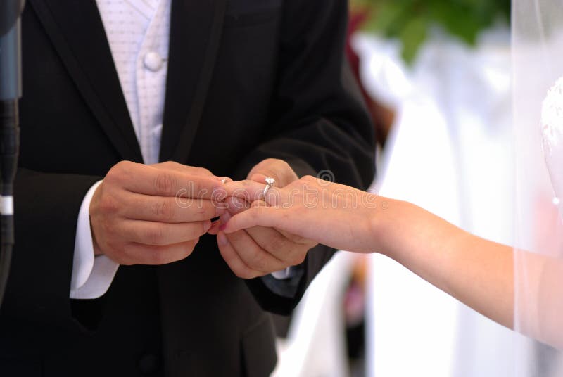 Exchange of rings at the wedding ceremony. The bride wears a wedding ring  on her groom's finger. Wedding day Stock Photo | Adobe Stock