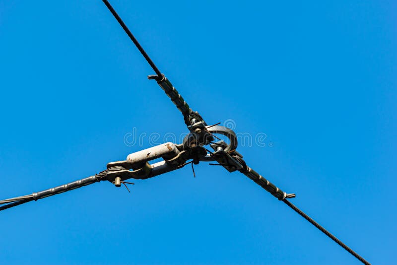 The ring keeps the metal cables together. Background of ringed wires against a blue sky royalty free stock photo
