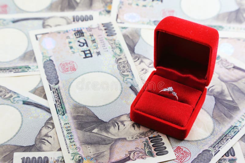 Wedding Ring in red box with yen banknotes in background. Wedding Ring in red box with yen banknotes in background