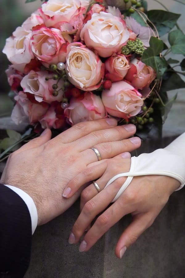 Manos anillos de novia a acicalar con una rosa.