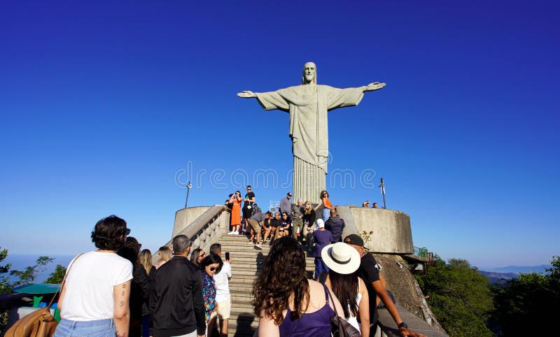 A crowd of people lined up to take a photo with the statue of Christ the Redeemer on