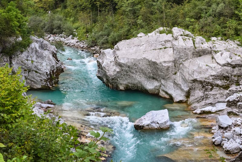 Rio de Soca perto de Kobarid, fluindo através da floresta verde luxúria no Eslovênia imagem de stock Rio de Soca perto de Kobarid, fluindo através da floresta verde luxúria no Eslovênia imagem de stock