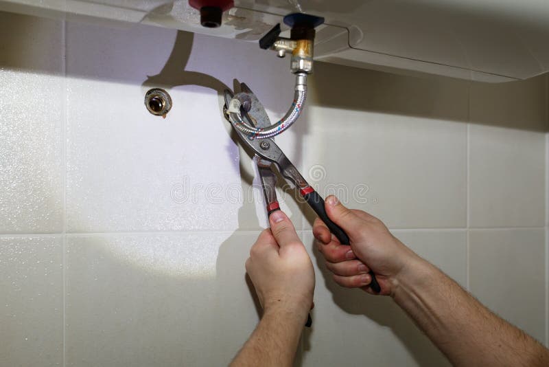 Water heater repair: cutting out a metal pipe with a tin snips. Water heater repair: cutting out a metal pipe with a tin snips