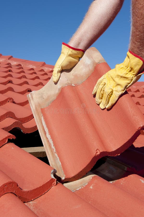 Riparazione di tetto delle mattonelle del muratore immagine stock libera da diritti Riparazione di tetto delle mattonelle del muratore immagine stock libera da diritti