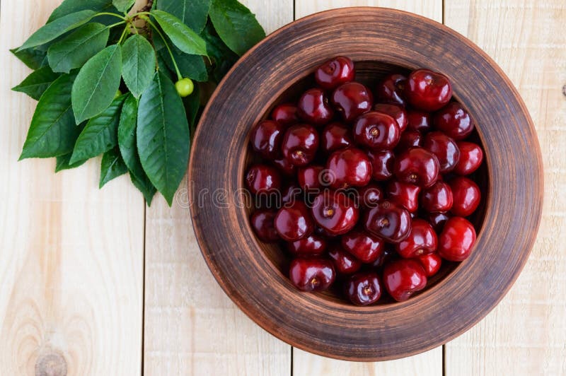 Ripe black cherries in a clay bowl stock images