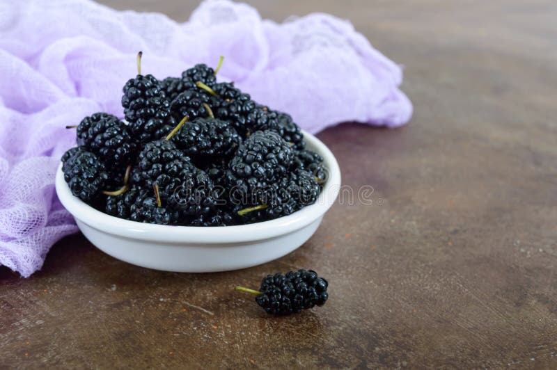 Ripe black mulberry in a bowl. royalty free stock photos