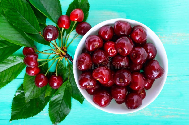 Ripe Juicy Red Cherries In A Ceramic Bowl On A Bright Wooden Background