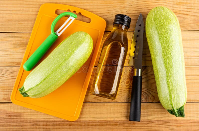 https://thumbs.dreamstime.com/b/ripe-marrow-squashes-green-peeler-cutting-board-bottle-vegetable-oil-kitchen-knife-wooden-table-top-view-159439420.jpg