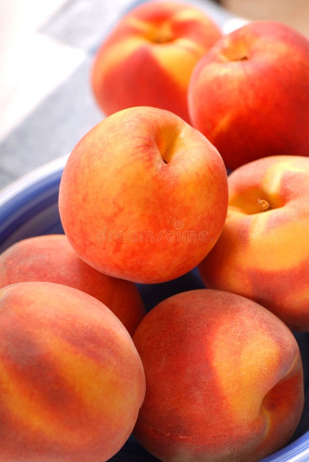 Ripe peaches in a blue bowl