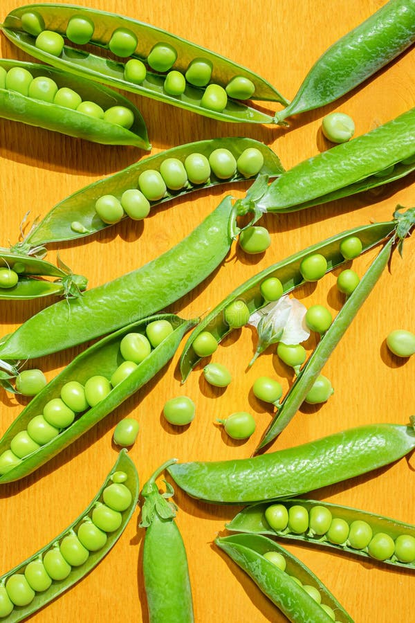 Ripe Peas In Pods On A Yellow Wooden Background Stock Photo - Image of ...
