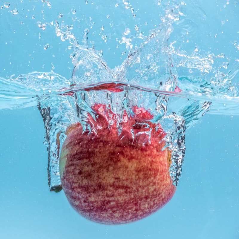 Ripe Red Apple is Falling into Clear Water, Forming Lots of Splashes ...