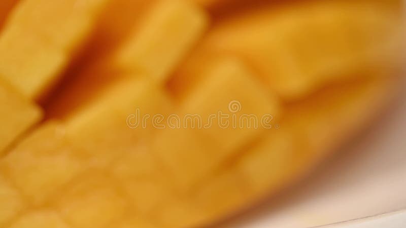 Ripe sliced juicy delicious Asian mango dice squared cubes cut moving in 4k slow motion