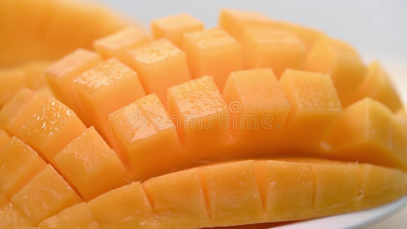 Ripe sliced juicy delicious Asian mango dice squared cubes cut moving in 4k slow motion