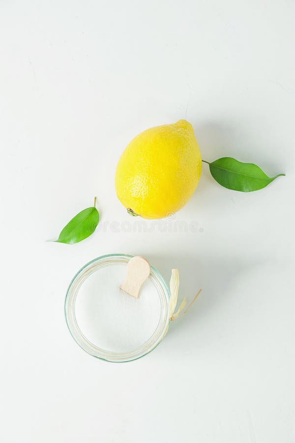 Ripe Yellow Lemon Green Citrus Leaves Sugar in Glass Jar. Ingredients for Face Scrub on White Concrete Stone stock photos Ripe Yellow Lemon Green Citrus Leaves Sugar in Glass Jar. Ingredients for Face Scrub on White Concrete Stone stock photos