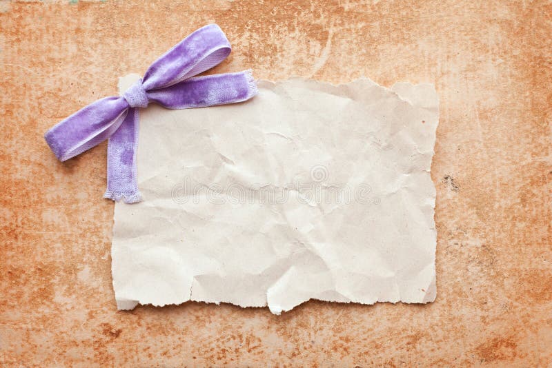 Ripped piece of paper with purple bow