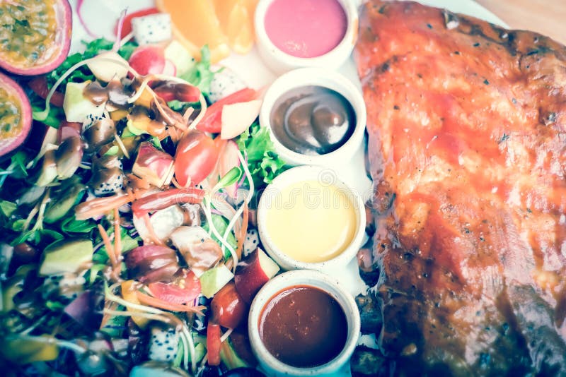 Rippen des gebratenen Schweinefleisch mit Barbecue-Soße und Obstsalat stockfotos Rippen des gebratenen Schweinefleisch mit Barbecue-Soße und Obstsalat stockfotos