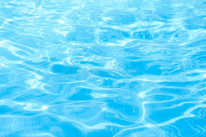 Rippled surface of blue swimming pool crystal clear water with sunlight highlights. Vibrant clean cayenne color. Summer vacation