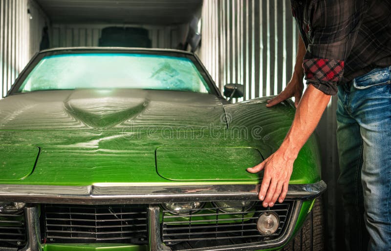Ripristino di un'auto verde d'annata in un contenitore di stoccaggio in un pomeriggio di sole immagine stock libera da diritti