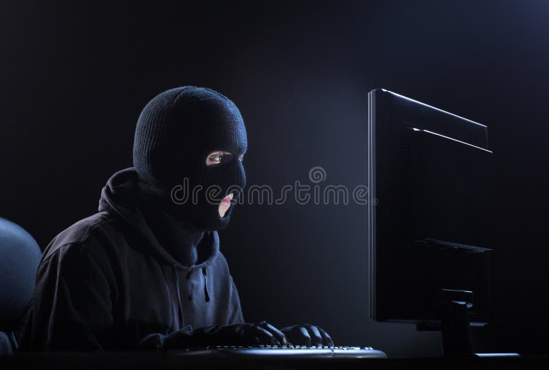 Computer hacker - Male thief stealing data from computer. Computer hacker - Male thief stealing data from computer