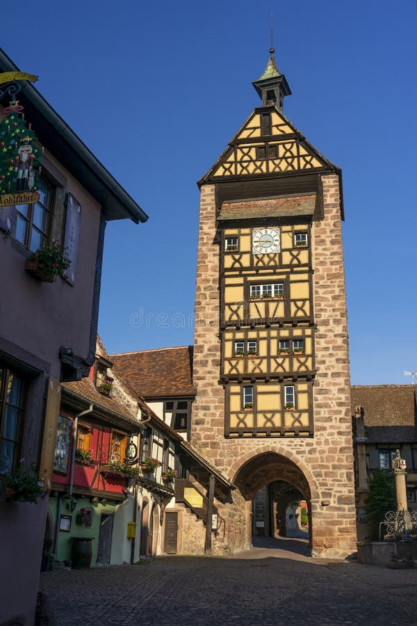 RIQUEWIHR FRANCJA MAJA 30 R. 2019 : Wieczór z wieżową wieżą i tradycyjnymi kolorowymi domami w Riquewihr fotografia royalty free