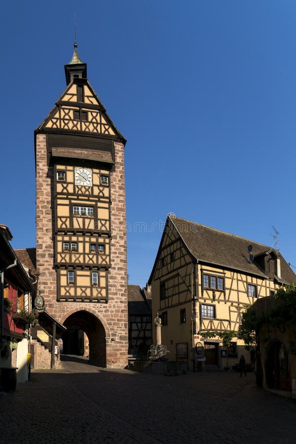 RIQUEWIHR FRANCJA MAJA 30 R. 2019 : Wieczór z wieżową wieżą i tradycyjnymi kolorowymi domami w Riquewihr obrazy stock
