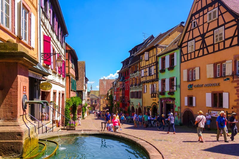 Riquewihr, Frankreich 23. Juni 2016: Touristen gehen auf die Haupteinkaufsstraße in Riquewihr stockbild Riquewihr, Frankreich 23. Juni 2016: Touristen gehen auf die Haupteinkaufsstraße in Riquewihr stockbild