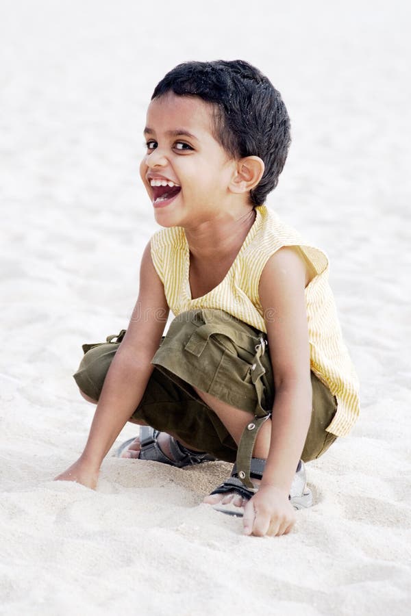 Little boy laughing while playing at the beach. Little boy laughing while playing at the beach