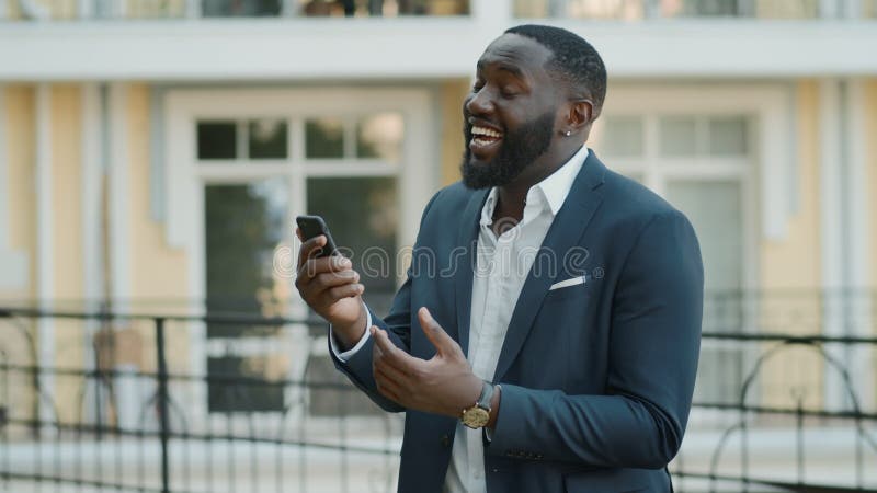 Risas empresario tener video chat afuera. afro man teniendo charla al aire libre almacen de video