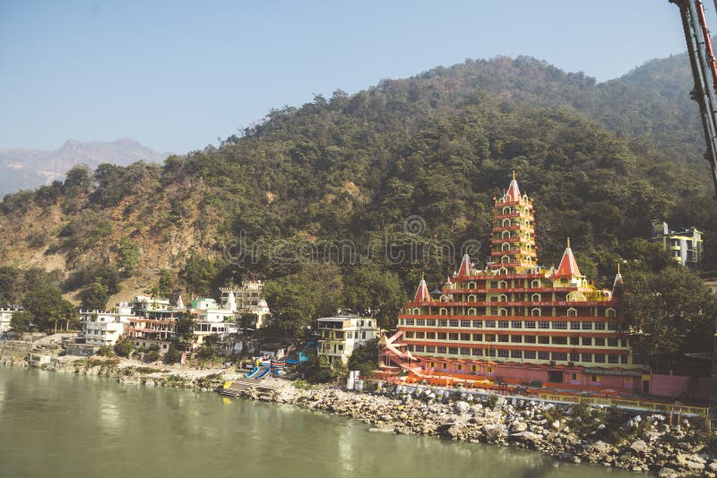 Rishikesh India. 10 January 2018. View of Ganga river embankment, Lakshman Jhula bridge and Tera Manzil Temple, Trimbakeshwar in