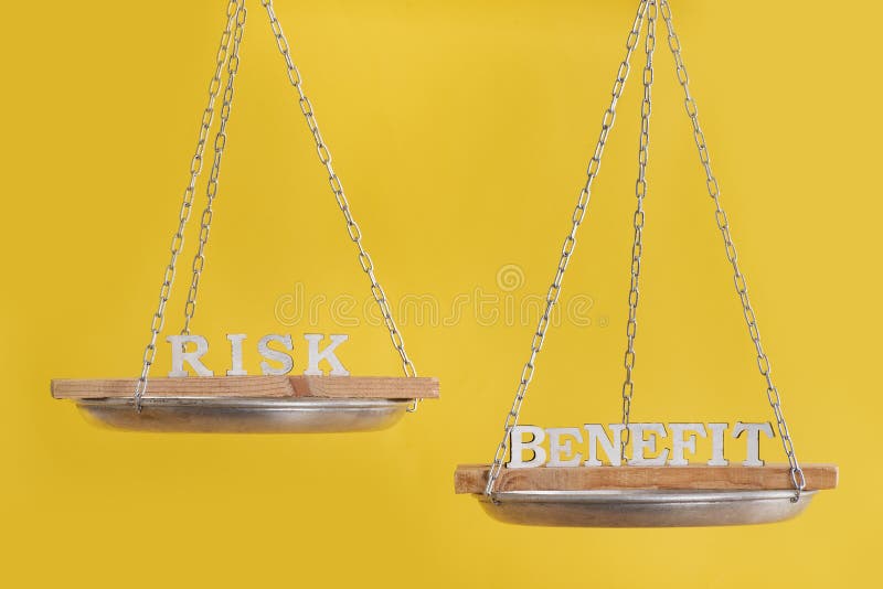 Risk vs benefit in balance. Concept of equilibrium. Balance scales on yellow background close up. Risk vs benefit in balance. Concept of equilibrium. Balance scales on yellow background close up.