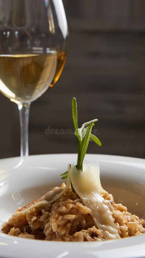 Risoto italiano do prato com os cogumelos e queijo parmesão brancos selvagens em uma placa branca fotos de stock royalty free Risoto italiano do prato com os cogumelos e queijo parmesão brancos selvagens em uma placa branca fotos de stock royalty free