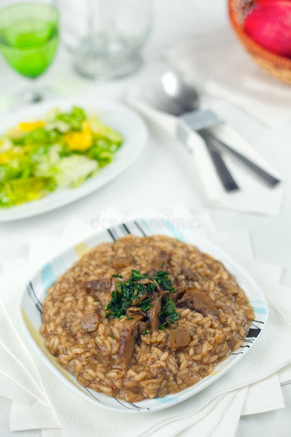 A course of Risotto with artichokes on a white prepared table