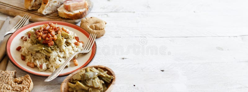 Risotto with artichokes and bacon top view on a wooden table