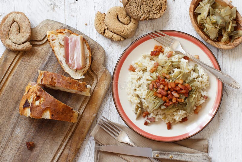 Risotto with artichokes and bacon top view on a wooden table top view